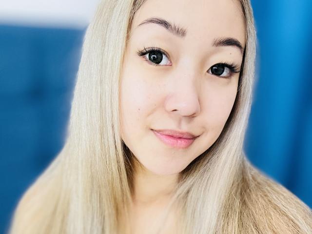 RenyLime heeft blond haar, groene ogen en roze lippen, met een lichte glimlach, en kijkt recht in de camera. Haar borsten zijn niet zichtbaar. Ze is schattig..