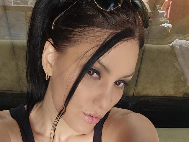 JoliDanielle ha i capelli scuri raccolti in una coda di cavallo, occhi marroni e labbra rosa lucide. Indossa degli occhiali da sole neri sulla testa e piccoli orecchini dorati. Il suo seno è leggermente visibile..