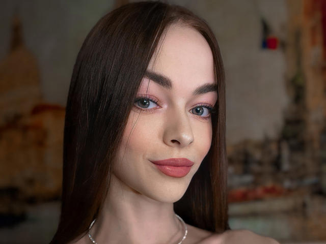 UnderTheSkin ha lunghi capelli castani, occhi verdi, palpebre rosa e labbra rosa, con un leggero sorriso. Indossa una collana d'argento e la sua pelle è molto chiara..