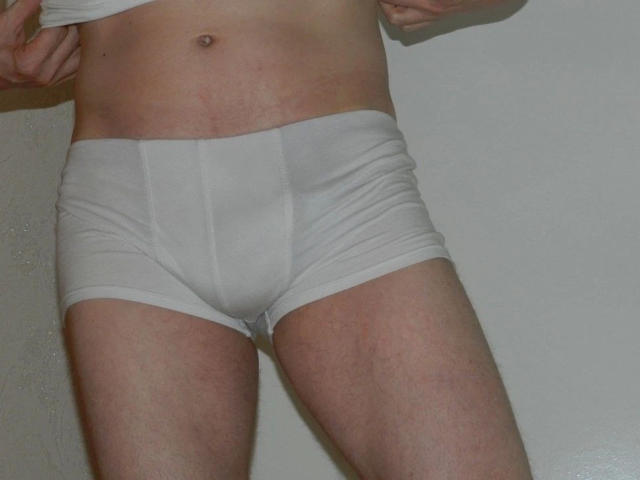 justfun72-hot in white boxer shorts, showing a slightly visible bulge, with pale skin and a small navel, against a plain background.