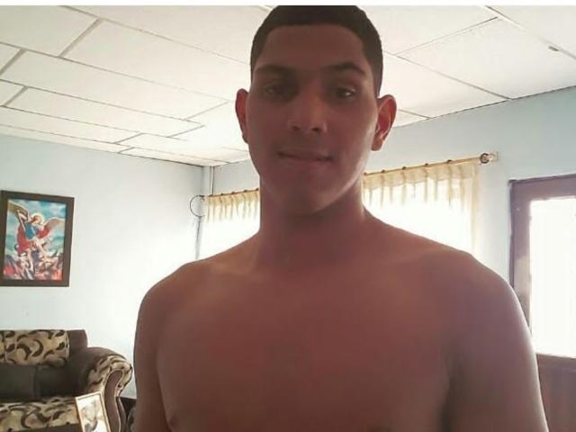 McBride, shirtless, has a clean-shaven face, short brown hair, and a slight smile. His chest is visible, showing a medium build and light skin.