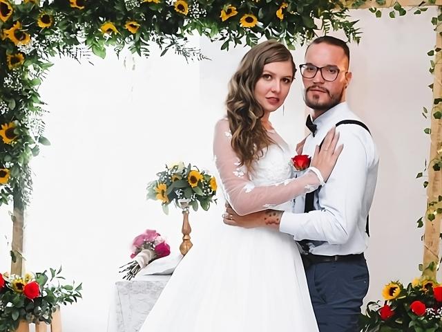 MsMiaMrSergio with wavy brown hair, white dress, and red rose, stands arms around MrSergio in white shirt and black pants, surrounded by sunflowers, holding her ass.