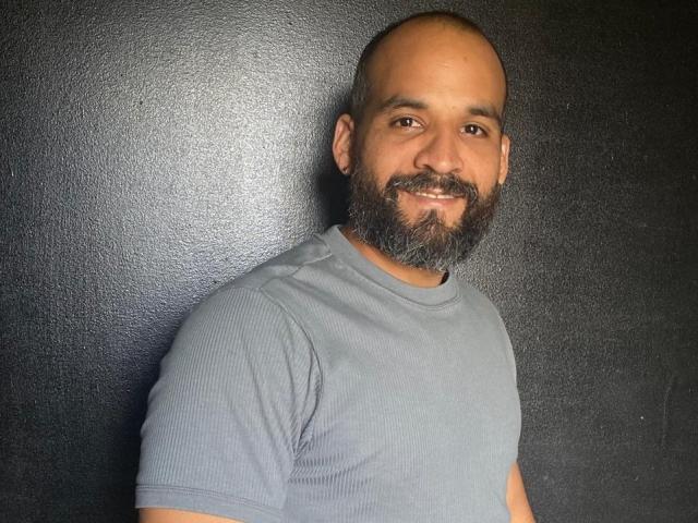 Minimalist drawing of a large, stylized flame with a dark red-orange center and subtle gradient. The flame is positioned slightly to the right, with textured, flat brush strokes.