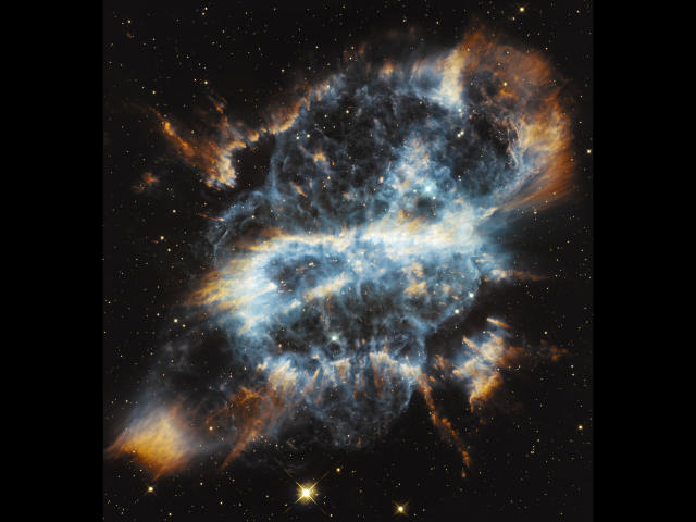 A fluffy blue and orange cosmic ass with glowing white center, surrounded by twinkling stars in a dark space. Froschhueter-hot's starry butt is looking hot in space.