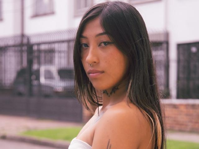 Digital illustration of a minimalist style, featuring a flat, pale-colored design with a prominent, slightly raised central emblem resembling a castle. Soft gradients and clean lines dominate the composition.