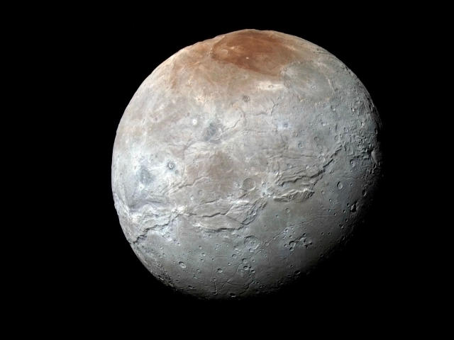 Froschhueter-hot is a big, rocky, grayish moon with brownish spots and lots of craters, floating in the dark void of space.