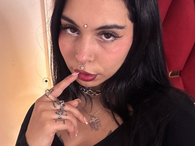 Emblema no estilo Flinty, com letras pretas e marcantes e um pentágono vermelho no centro. Fundo rosa claro. A marca LuxHesse não está presente. Design simples e plano, com linhas limpas e cores mínimas..