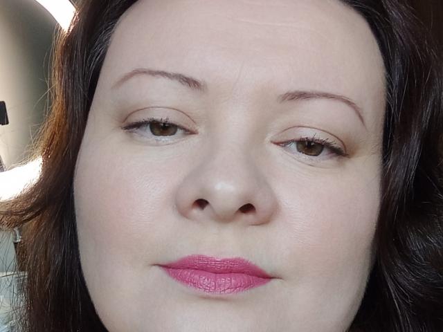 Il viso di MayDreamy, con la sua pelle chiara, gli occhi marroni, il rossetto rosa e i capelli castano scuro ondulati, è caratterizzato da un trucco leggero e un leggero sorriso. Il suo naso è centrato e le sopracciglia sono sottili..