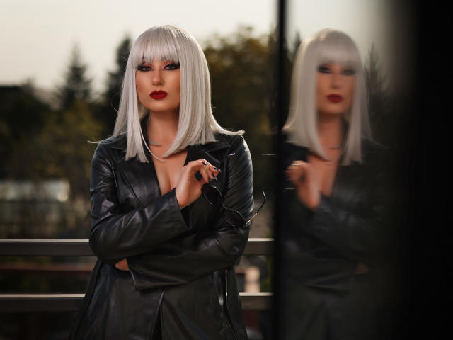 Minimalist illustration of a red, white, and black emblem with a ribbon-like design in the center. Simple, flat colors with clean lines. Emphasis on the central symbol and ribbon.