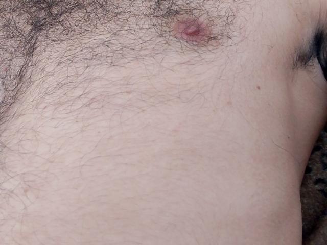 Dannh's hairy chest with a small, pink nipple in the upper right corner. Pale skin, visible armpit hair on the right side.