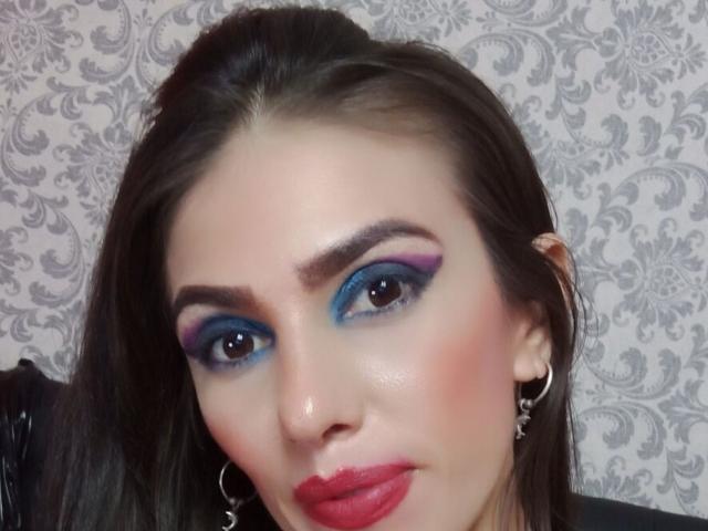 Shares heeft blauwe en paarse oogschaduw, donkere wenkbrauwen, rode lippenstift en draagt ster-vormige oorbellen. Haar bruine haar is recht en ze glimlacht lichtjes..
