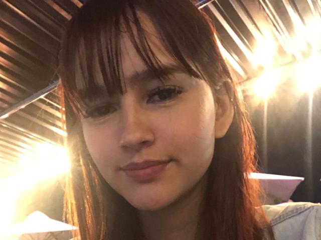 MelodyMansson's face, with wet brown hair, small nose, and subtle smile, has soft skin and is wearing a light-colored shirt. She has small tits and dark eyes.