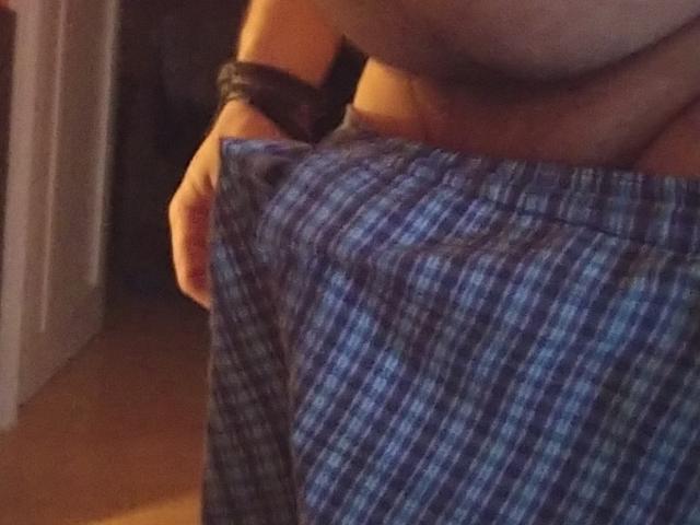OndraSekCZech's hand holds up a blue and white checkered skirt, exposing their large bare tits and a black wristband. The lower part of their torso is visible.