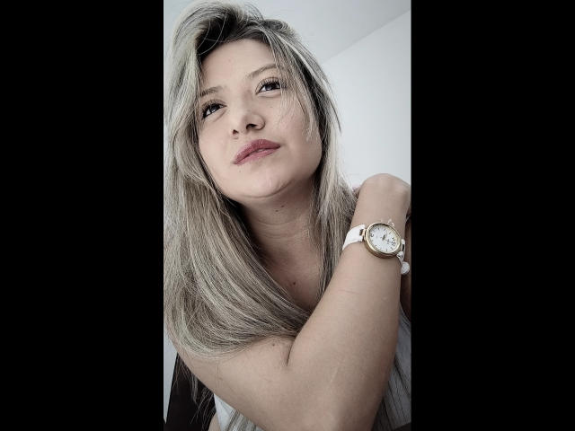ValeriaHunter69 has grayish-blonde hair, a white wristwatch, and a slightly smug expression. Her arm is raised, showing subtle stretch marks. She's looking to the side.