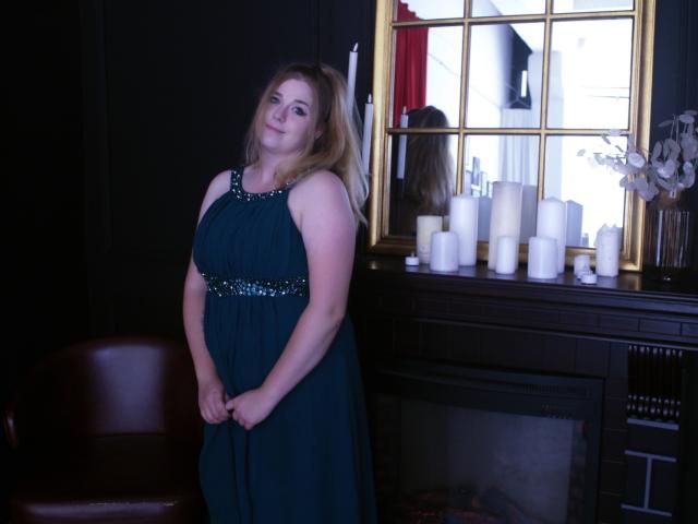 A minimalist, digital illustration of a European-style heraldic emblem with a red and white design. The emblem features bold, geometric shapes and a central, vertical, red element.