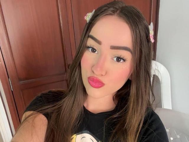 Antonia Sanchez ha lunghi capelli castani, rossetto rosa e mollette rosa. Indossa una maglietta nera con una stampa a tema cartone animato, ed è seduta su una sedia bianca, con una sedia sullo sfondo..