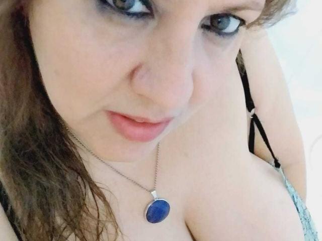 HotBabeIsuckI ha la pelle chiara, i capelli castani ondulati, gli occhi azzurri e indossa una collana con una pietra blu. Il suo seno prosperoso è visibile sotto una canotta nera con spalline..