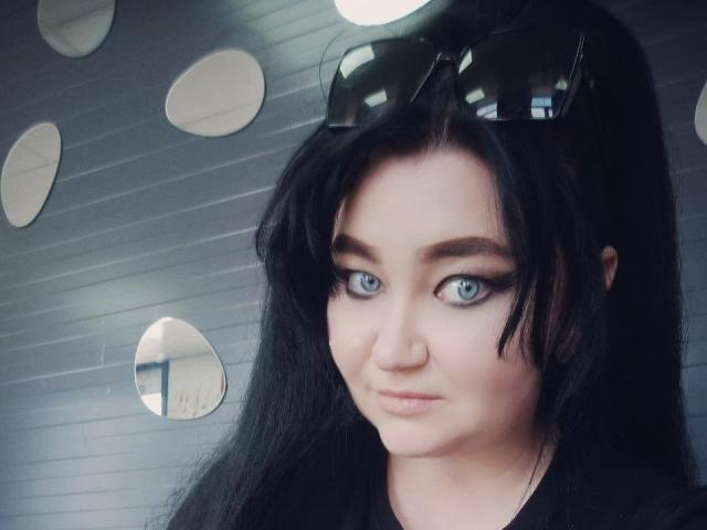 A KrooxJust tem a pele clara, olhos azuis, delineador preto e cabelo preto comprido, com óculos de sol na cabeça. Seu nariz pequeno e leve sorriso são visíveis..