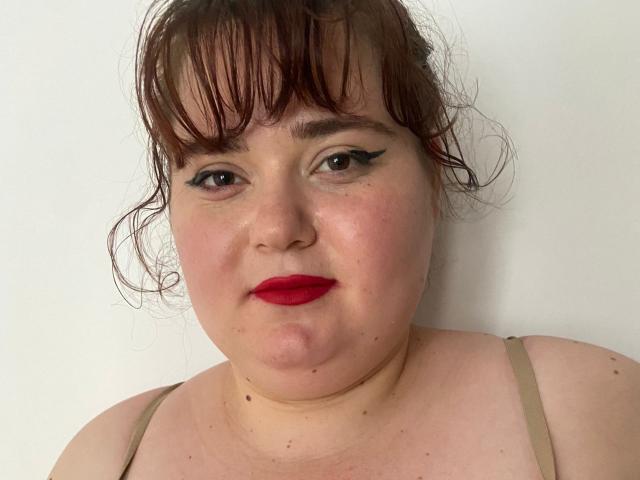 SarahSteelX ha il rossetto rosso, l'eyeliner nero e i capelli castani spettinati. È un po' in carne, con lentiggini, pelle chiara e indossa un reggiseno beige. Ha il seno piccolo ed è senza maglietta..