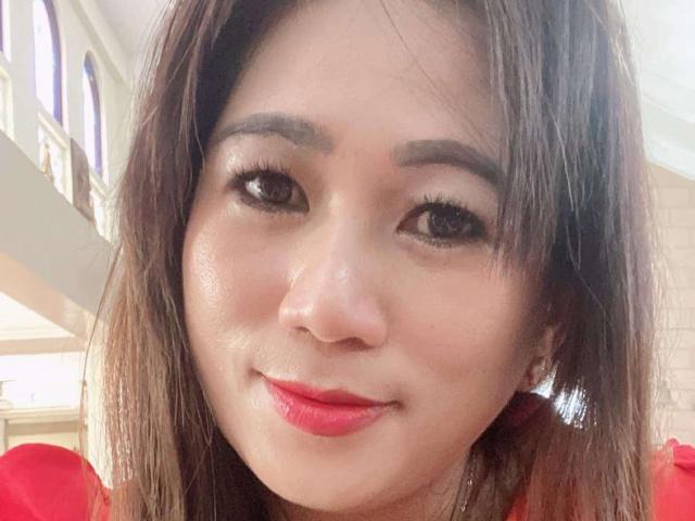 RiverSquirt has a cute, smiling face with brown eyes, red lipstick, and shiny, straight brown hair, wearing a red top. Her eyebrows are thick and well-groomed.
