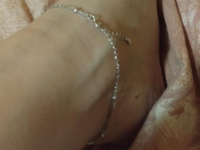 JuliaHuntis' pale, slightly veiny, and soft-skinned belly with a delicate, silver chain bracelet resting on her right side, near her navel.
