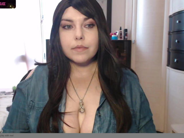 WhitteLotus with long brown hair, blue eyes, and a slightly open denim shirt showing her tits, wearing a necklace with a pendant, looking straight at the camera.