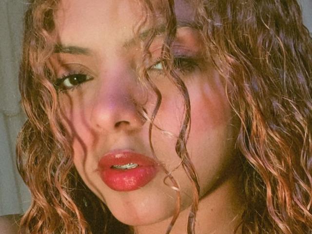 Close-up of a medieval-style letter "V" in bold, red, serif font. Valiente's letter is centered, with soft shading and subtle gradients. Simple, clean design with a classic feel.