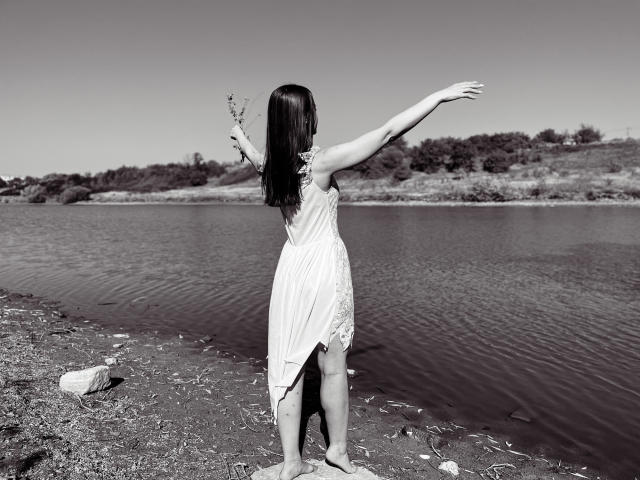 A flat, minimalist design featuring a large, bold letter "B" in the center. The letter has a subtle gradient from dark to light, with a small, white dot inside.