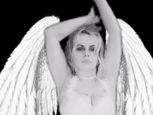RebeccaDarling69 with angel wings, arms raised, wearing a fluffy white bra, blonde hair, serious expression, black background, white feathers, soft light, white necklace, upper body shot.