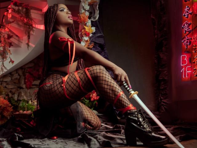 LindaBird with dark skin, long braids, red ribbon top, fishnet stockings, black boots, holding a sword, kneeling on a black satin cloth, red neon light on the right.