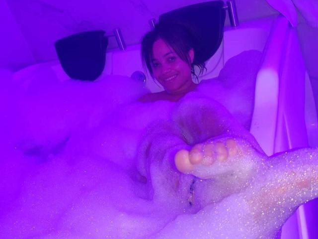 A flat, stylized design featuring a large, bold, vertical letter "V" in the center. The "V" has a subtle, light brown gradient and a slight shadow.