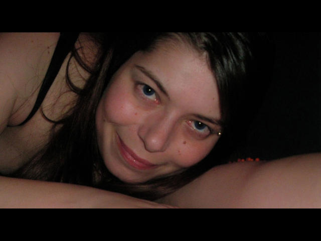 Chiara177-hot has blue eyes, brown hair, and a slight smile with a small nose piercing. She's leaning forward with her tits barely visible. Her skin is fair.