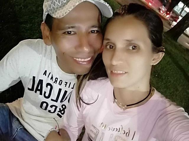 HannaYJulian con i capelli scuri, che indossa una camicia rosa e una collana nera, e HannaYJulian con un berretto da baseball e una camicia bianca, entrambe sorridenti in un selfie..