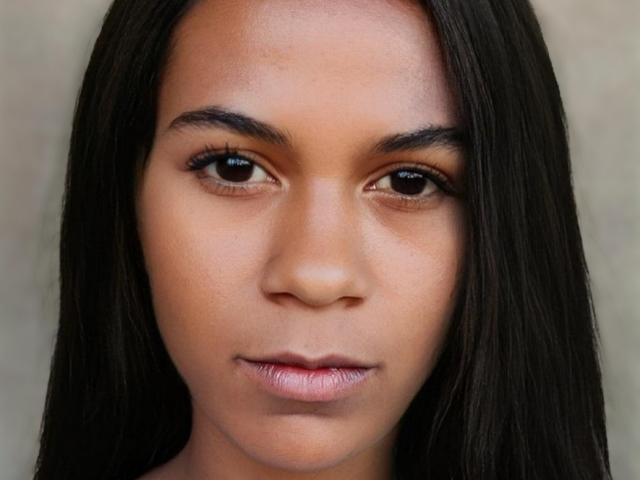 JessyBlacko has brown skin, long black straight hair, and brown eyes with full lips. She's looking straight at the camera with a serious expression. Her tits are not visible.