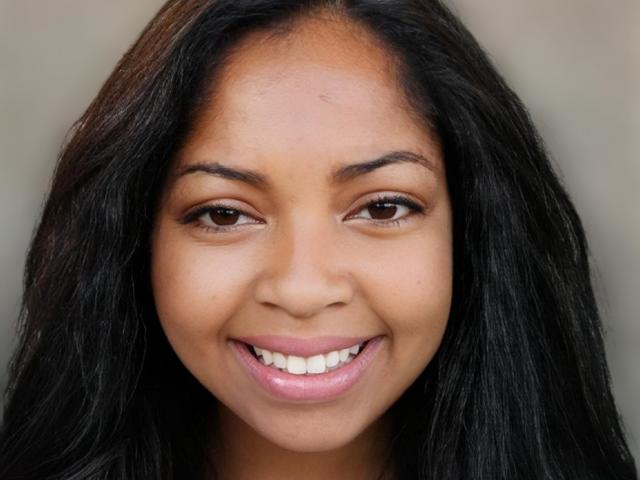 PegySexy has dark brown eyes, long black hair, and a smile showing white teeth. Her skin is a warm brown tone, and she's wearing pink lipstick.