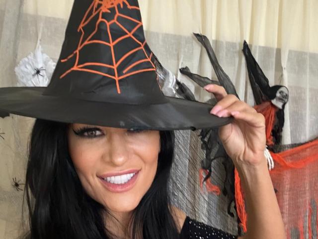 A digital illustration of a red and black emblem with stylized lettering, resembling a medieval or fantasy design. The emblem is centered with bold lines and a slightly curved bottom.