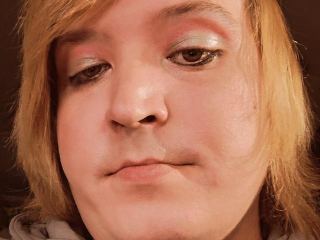 El rostro de AvaBrayns muestra una expresión ligeramente afligida, con ojos de color rosa, cabello castaño claro y un ligero brillo en la piel, luciendo un poco cansada..