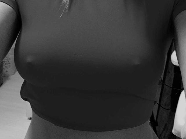 IngridI's tits are visible through a tight black shirt, with nipples clearly outlined. The image is a black-and-white photo.
