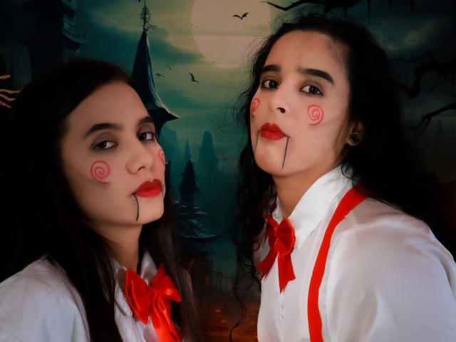 Dilan y Mia tienen la piel clara, cabello negro ondulado, lápiz labial rojo y remolinos rojos en las mejillas con líneas negras. Llevan camisetas blancas con lazos rojos y tirantes..