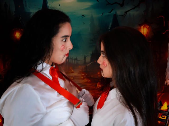 Dilan y Mia, con cabello oscuro, camisa blanca, corbata roja y tirantes, mirando a Mia, que lleva un atuendo similar y maquillaje facial, en un bosque misterioso iluminado por la luna, tocándose los tirantes..