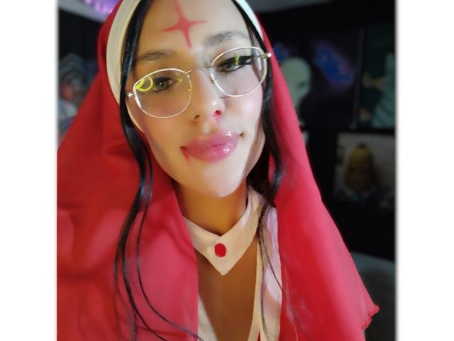 ErotiicAlexa with shiny glasses, red veil, red star on forehead, pink lips, white choker, and red cross, smiling, showing a slight sheen on her face, looking cute.