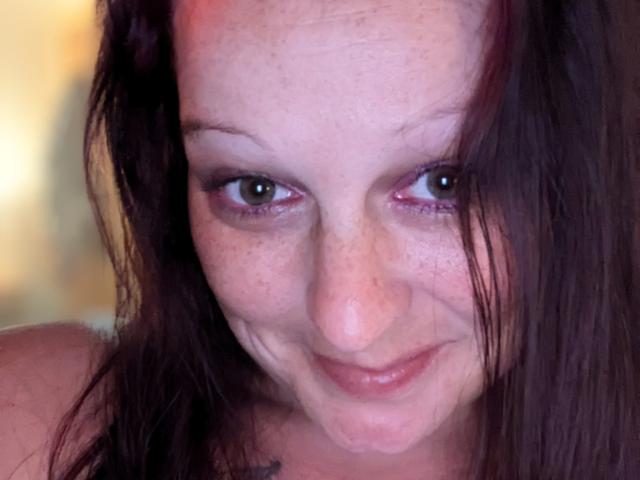 Lusciousness has freckled skin, dark brown hair, and a slight smile, with subtle makeup and a gentle, sexy gaze. Her small nose and pink lips add to her charm.