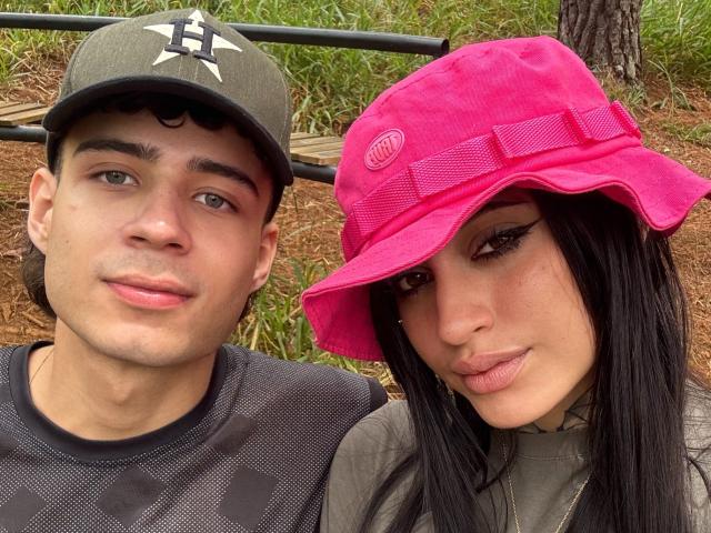 SofiaAndgeordi, com uma carinha fofa, usando um boné rosa e cabelo preto, ao lado de SofiaAndgeordi, que está usando um boné verde e uma camisa preta. SofiaAndgeordi tem olhos verdes..