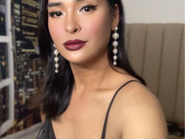 HugeTopMistressEricka69 has medium tits, dark brown hair, and is wearing black lace lingerie with pearl earrings. She has dark red lipstick and a cute, sexy look.