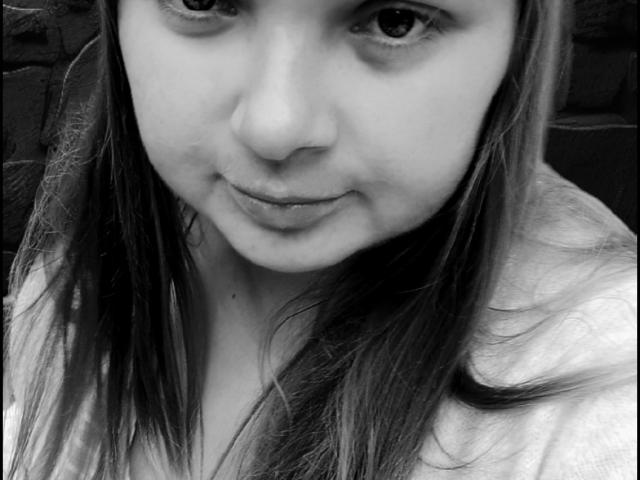 Black and white selfie of DorothySummer with long hair, slightly parted lips, and a subtle smile. Her nose is small and her eyes are dark and slightly upturned.