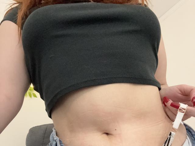 De zwarte, geribbelde crop top van Rubbi laat haar blote buik zien, met een zichtbare navel en lichte stretchmarks. Ze trekt haar jeans naar beneden, waardoor witte onderbroek te zien is..