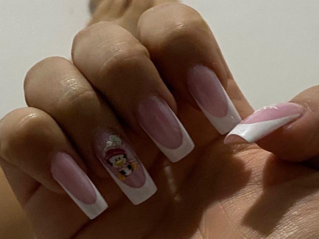 AilenTovar's hand with long, pink and white French tip nails, featuring a tiny, colorful cartoon on the pinky. Boobs are not visible, but her nails are super cute.
