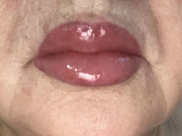 PeggySoft's glossy pink lips are slightly parted, showing a hint of her upper teeth, with a subtle sheen on her full, plump lower lip.