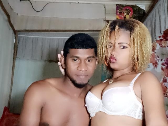 MeriAndMark, a black guy with short curly hair and a goatee, and MeriAndMark, a black woman with curly blonde hair, wearing orange earrings and red lipstick.