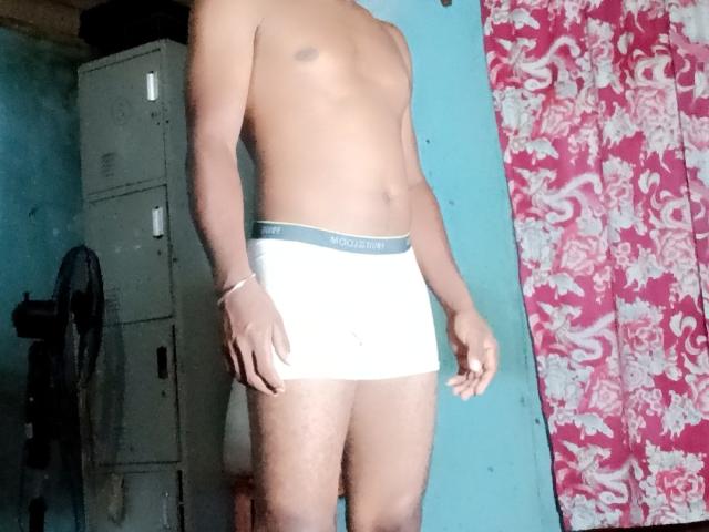 MeriAndMark, a dark-skinned dude, wearing white Calvin Klein briefs, showing a slim, muscular build with a small, tight ass, standing in a room with a mirror.